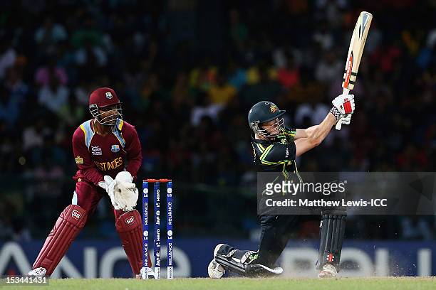 George Bailey of Australia hits a six, as Denesh Ramdin of the West Indies looks on during the ICC World Twenty20 2012 Semi Final match between...