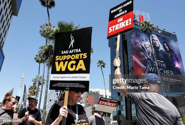 Sign reads 'SAG-AFTRA Supports WGA' as SAG-AFTRA members walk the picket line in solidarity with striking WGA workers outside Netflix offices on July...