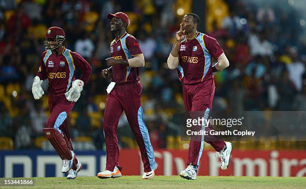 Kieron Pollard of the West Indies celebrates with Danesh Ramdin and Darren Sammy after dismissing Pat Cummins of Australia during the ICC World...