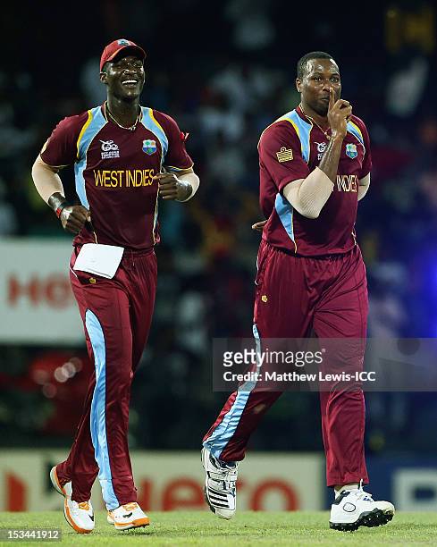 Kieron Pollard of the West Indies celebrates the wicket of Pat Cummins of Australia with Darren Sammy, after he was caught by Johnson Charles during...