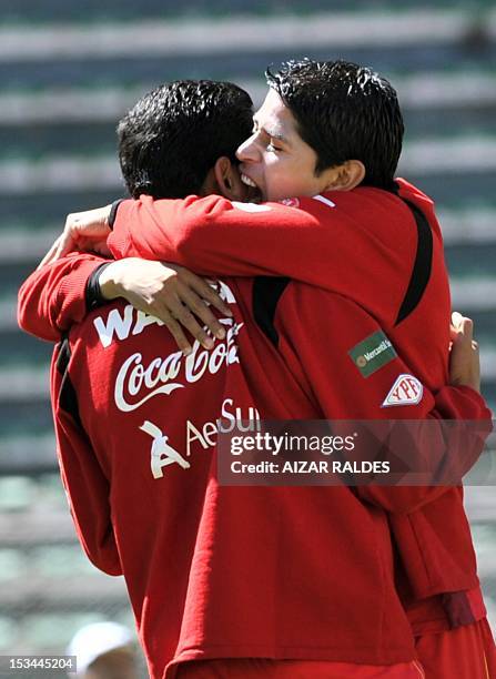 Bolivian players Jose Carlos Barbas and Edward Zenteno share a joke during a training session in La Paz on October 05 in La Paz. Bolivia will face...