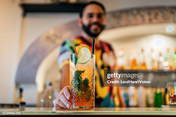 bartender serving a cocktail drink on a bar counter - malta business stock pictures, royalty-free photos & images