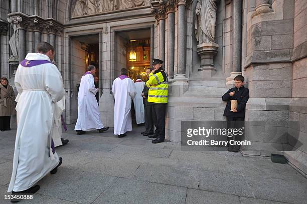 Young boy eats chips as members of the clergy arrive for a Memorial Service for murdered journalist Jill Meagher at St. Peter's Church on October 5,...