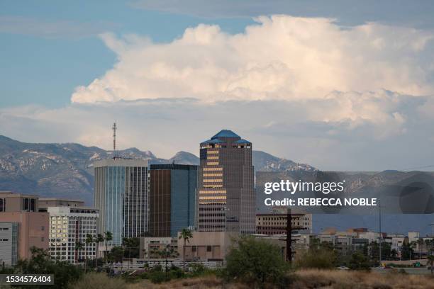 Storm clouds loom behind the downtown skyline during a heat wave in Tucson, Arizona, on July 15, 2023. Brutally high temperatures threatened tens of...