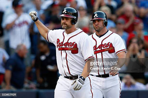 David Ross of the Atlanta Braves reacts as he heads back to the dugout in front of teammate Dan Uggla after Ross hits a two-run home run in the...