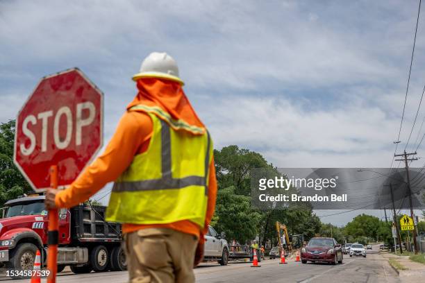 Construction worker ushers traffic on July 11, 2023 in Austin, Texas. Record-breaking temperatures continue soaring as prolonged heatwaves sweep...