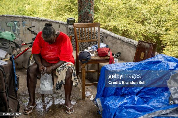Andrea Washington sits after pouring water on herself in the Hungry Hill neighborhood on July 11, 2023 in Austin, Texas. Washington began to cry as...