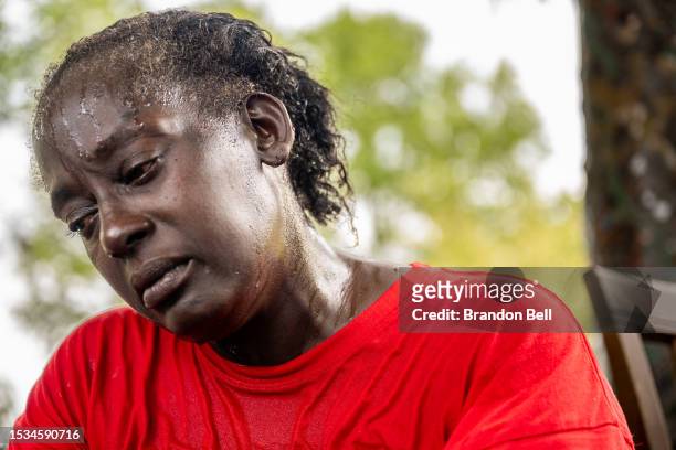 Andrea Washington weeps after pouring water on herself in the Hungry Hill neighborhood on July 11, 2023 in Austin, Texas. Washington began to cry as...