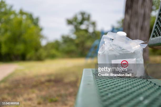 An Austin Area Urban League water pouch is seen on a park bench in the Hungry Hill neighborhood on July 11, 2023 in Austin, Texas. Record-breaking...