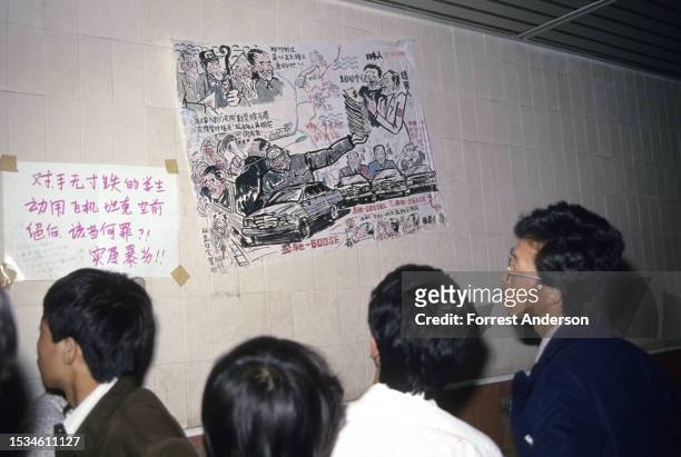 Onlookers reads anti-corruption cartoons at Tiananmen Square during a pro-democracy demonstration, Beijing, China, May 31, 1989.