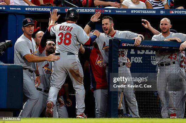 Pete Kozma of the St. Louis Cardinals celebrates after he scores in the seventh inning on a bunt by Matt Carpenter against the St. Louis Cardinals...