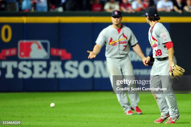 Matt Holliday and Pete Kozma of the St. Louis Cardinals react after the ball hits the grass as the infield fly rule is called in the eighth inning on...