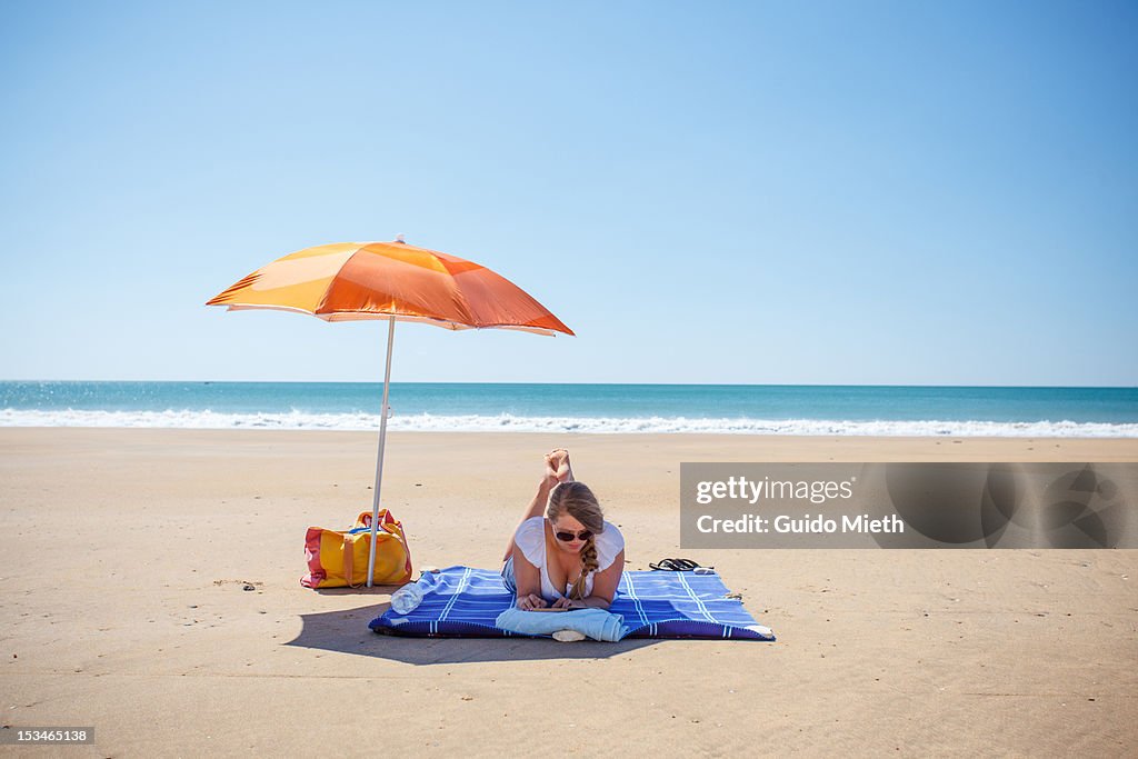 Woman with book on beach