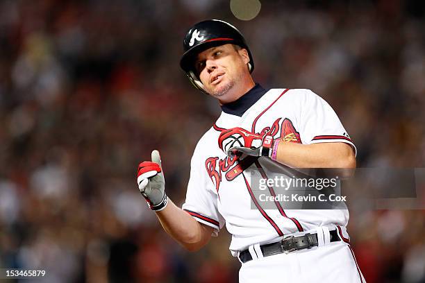 Chipper Jones of the Atlanta Braves reacts after he is safe at first base after beating out a throw to extend the game in the ninth inning against...