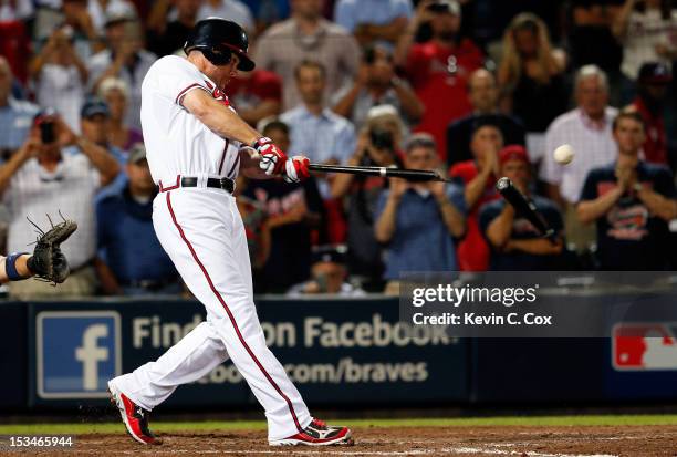 Chipper Jones of the Atlanta Braves breaks his bat as he hits an infield single to extend the game in the ninth inning against the St. Louis...