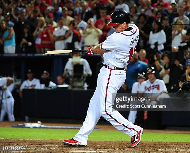 Chipper Jones of the Atlanta Braves breaks his bat hitting for a single in his last career at bat against the St. Louis Cardinals during the National...