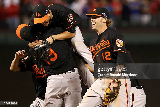 Chris Davis, Manny Machado Mark Reynolds of the Baltimore Orioles celebrate after they won 5-1 against the Texas Rangers during the American League...