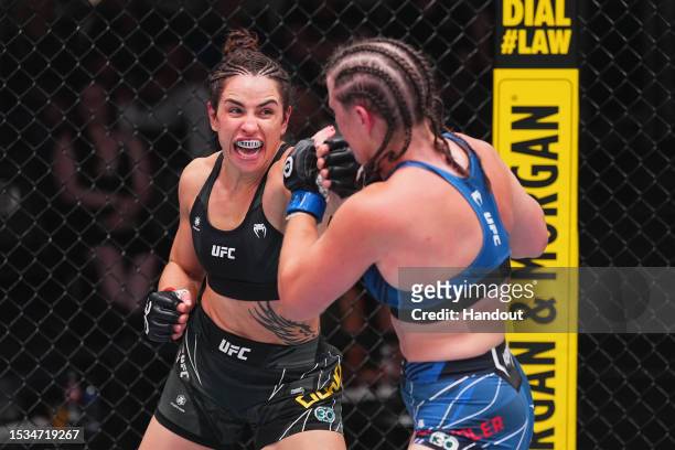 In this handout image provided by UFC, Norma Dumont of Brazil punches Chelsea Chandler in their featherweight fight during the UFC Fight Night at UFC...