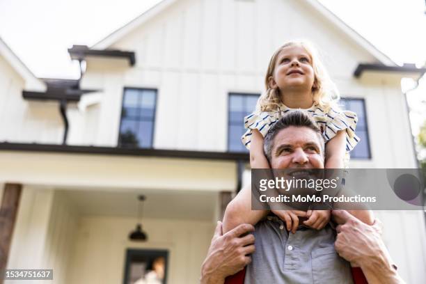father and daughter in front of suburban home - area 51 stock-fotos und bilder
