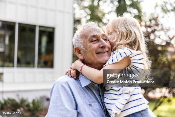 grandfather and daughter in front of suburban home - kleinkind stockfoto's en -beelden