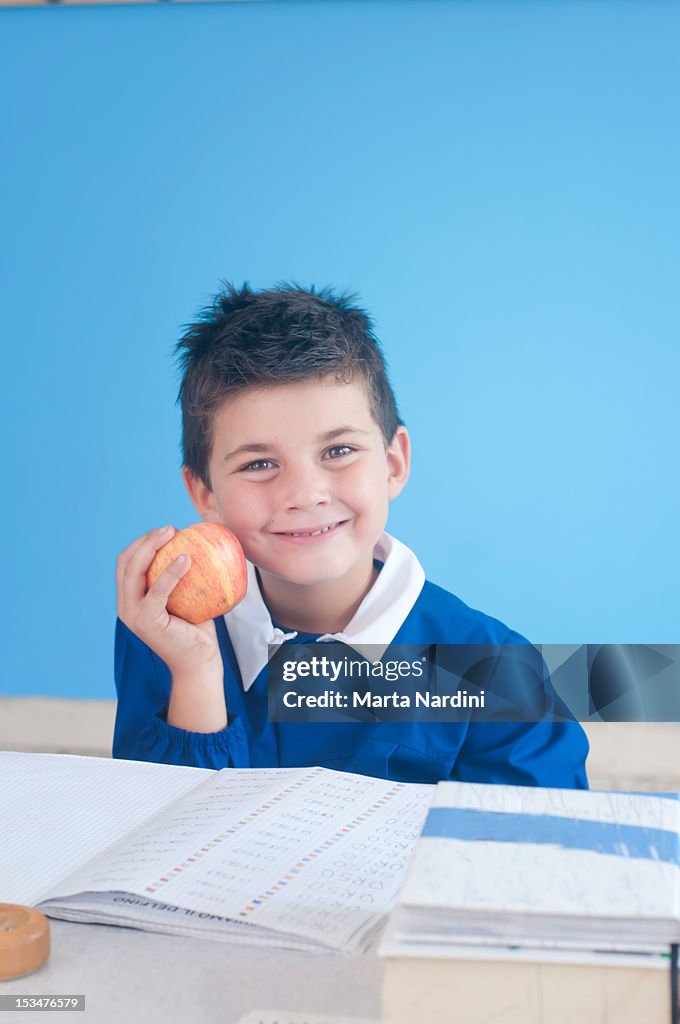 Child holding apple at school