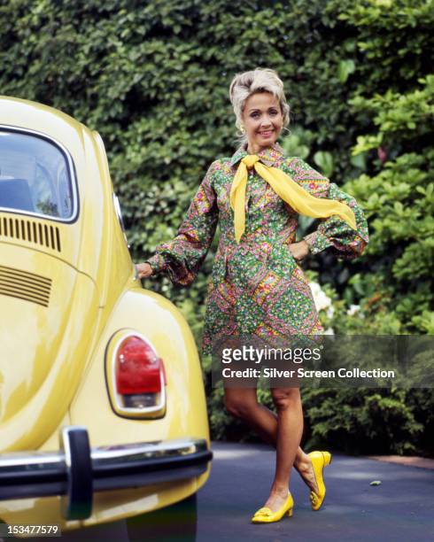 American singer, dancer and actress Jane Powell standing next to a Volkswagen Beetle, circa 1970.