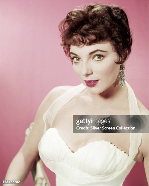 English actress Joan Collins in a white evening dress, circa 1955.