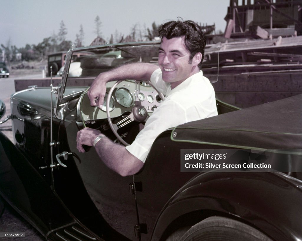 Show Rory Calhoun American actor Rory Calhoun at the wheel of an MG sports car, circa ...