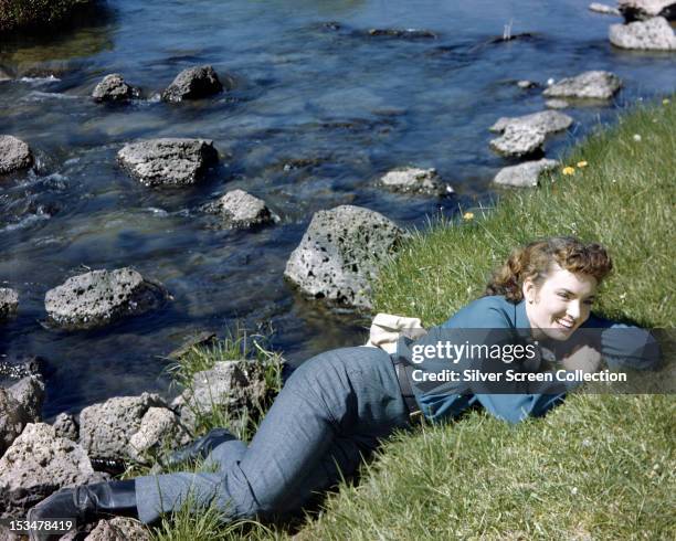 American actress and singer Ann Blyth lying by a rocky stream, circa 1945.