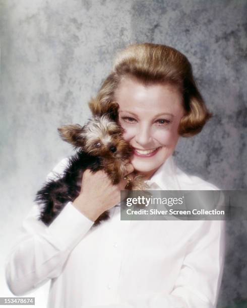 American actress June Allyson holding a yorkshire terrier, circa 1955.