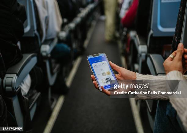 a woman shows her air ticket to a friend on a commercial aircraft - plane stock pictures, royalty-free photos & images