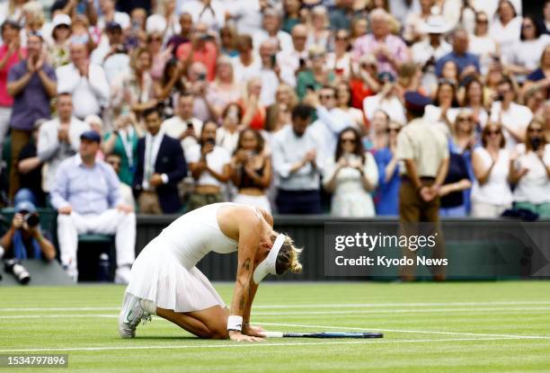 Marketa Vondrousova of the Czech Republic drops to her knees after beating Ons Jabeur of Tunisia in the women's singles final at the Wimbledon tennis...