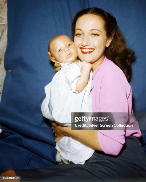 American actress and singer Dorothy Lamour posing with a baby - one of her two sons, 1946 or 1949.