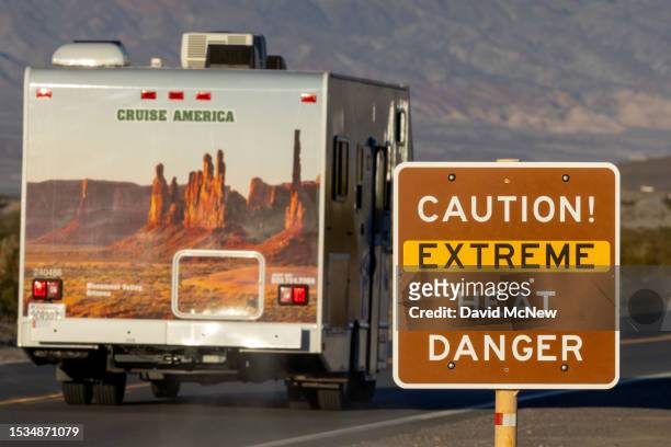 Rental RV passes a sign warning of extreme heat danger on the eve of a day that could set a new world heat record in Death Valley National Park on...