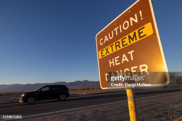 Car passes a sign warning of extreme heat danger on the eve of a day that could set a new world heat record in Death Valley National Park on July 15,...