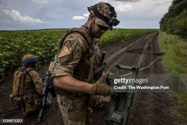 Soldier prepare to remove an anti tank mine by tying a rope around a detonator during a mine clearance exercise on July 11 2023, in Dnipropetrovsk...