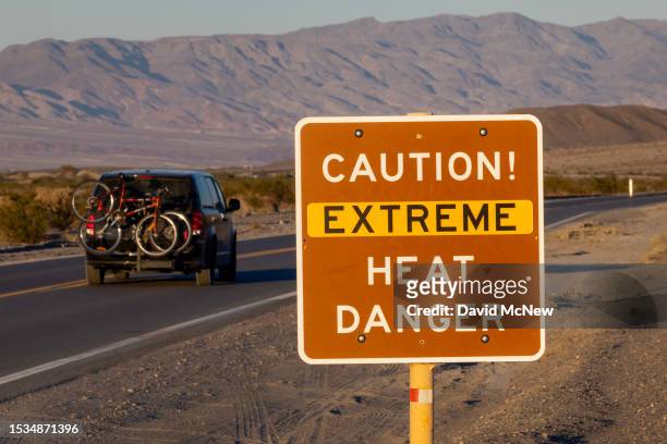Car passes a sign warning of extreme heat danger on the eve of a day that could set a new world heat record in Death Valley National Park on July 15,...
