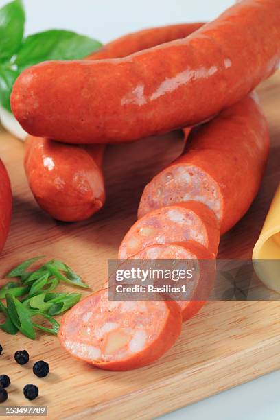 spicy meat sausages on a chopping board - rookworst stockfoto's en -beelden