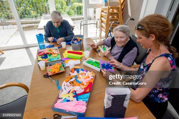 active seniors in a nursing home - elderly cognitive stimulation therapy stockfoto's en -beelden