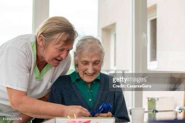 cuidadora feliz y un retrato de mujer mayor - residential care fotografías e imágenes de stock
