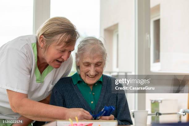 happy caregiver and a senior woman portrait - residential care stock pictures, royalty-free photos & images