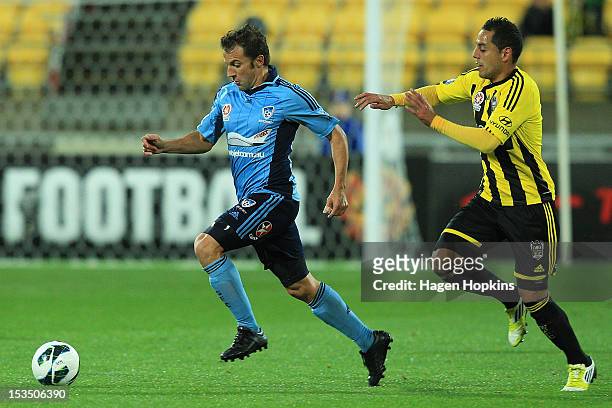 Alessandro Del Piero of Sydney FC runs the ball under pressure from Leo Bertos of the Phoenix during the round one A-League match between the...