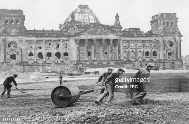 Workers flatten the wasteground in front of the ruined Reichstag in West Berlin, in preparation for the 'Day of National Work' on May 1st, circa 1947.