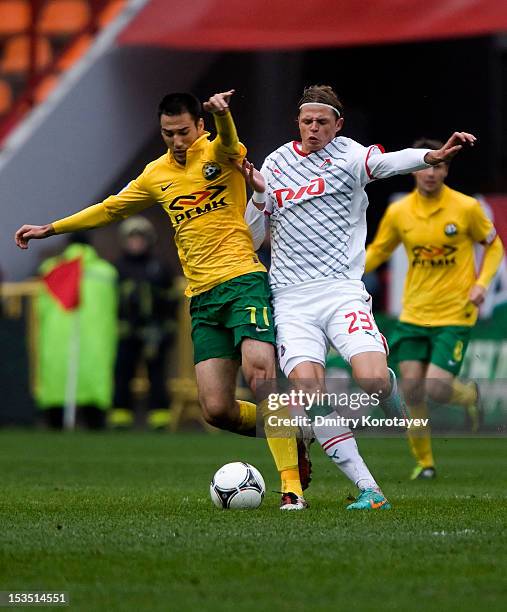 Dmitri Tarasov of FC Lokomotiv Moscow battles for the ball with Ivelin Popov of FC Kuban Krasnodar during the Russian Premier League match between FC...