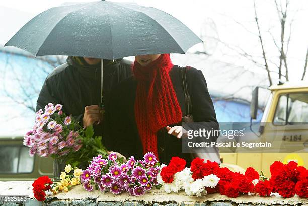 Russian couple leaves flowers in front of the Moscow theater October 27, 2002 in Moscow. Russian special forces used a sleep-inducing gas to release...