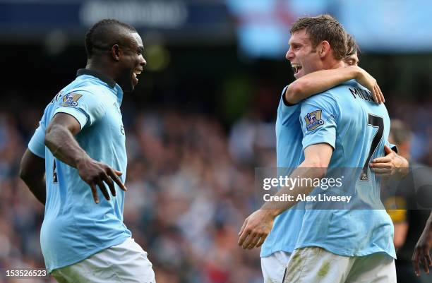 James Milner of Manchester City celebrates scoring his team's third goal with team-mate Micah Richards during the Barclays Premier League match...