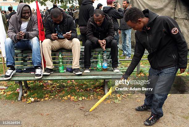 Somali refugee draws a map of his country on the ground with an umbrella for three fellow refugees from Sudan upon their arrival on October 6, 2012...