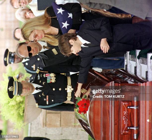 Chesare Bono places a rose on the casket of his father Sonny Bono as his mother Mary Bono holds the U.S. Flag during the burial ceremony of the...