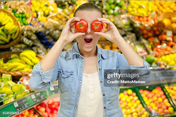 girl puts to tomatoes in front of her eyes - apple face stock pictures, royalty-free photos & images