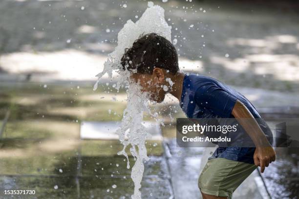 Child holds water from a fountain on his face to cool off at Kugulu Park in capital Ankara, Turkiye on July 16, 2023.